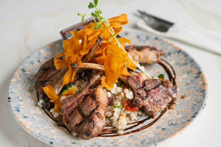 Steak topped with crispy garnish on a plate
