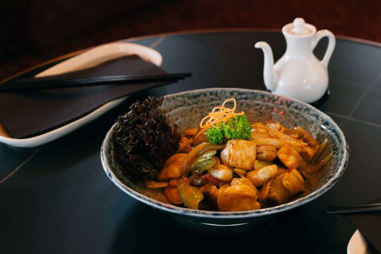 Chicken stir-fry with vegetables and cashews served in a ceramic bowl at Wok O’Clock Cairns.