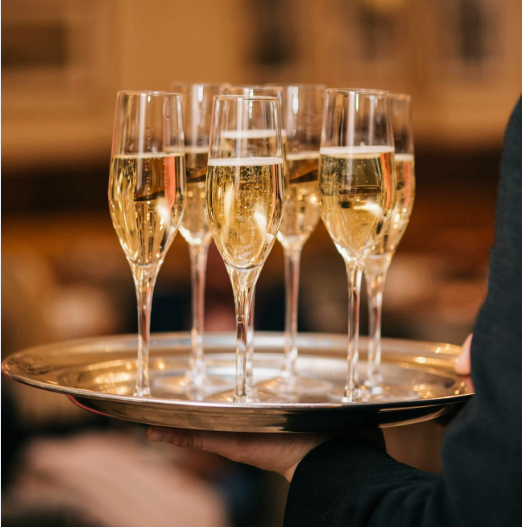 Glasses of sparkling wine lined up at a function bar
